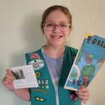 (Photo provided) Gretchen Schultz holds up a pamphlet and a card about her book.