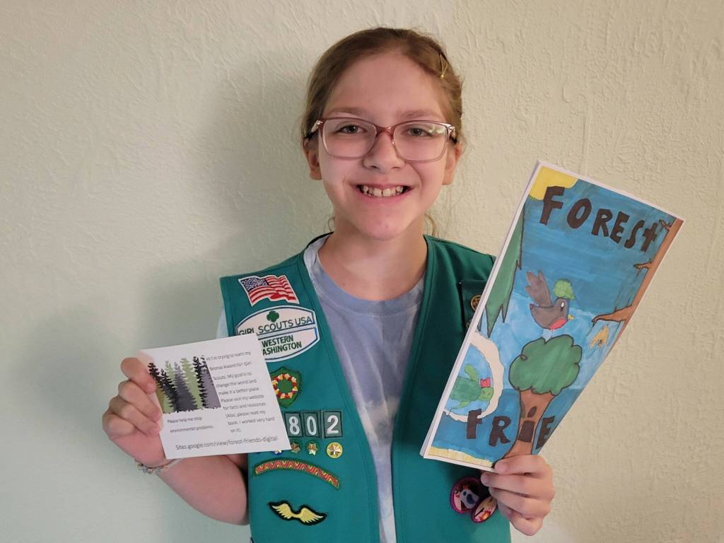 (Photo provided) Gretchen Schultz holds up a pamphlet and a card about her book.