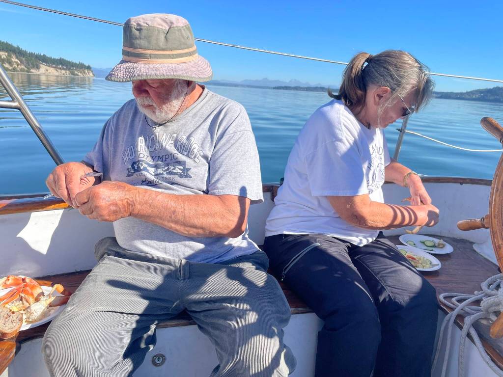 (Photo by Marina Blatt) Bill Smith and Carla Holderman feast on crab legs and soak in the sun aboard Bills boat, the Culmination.