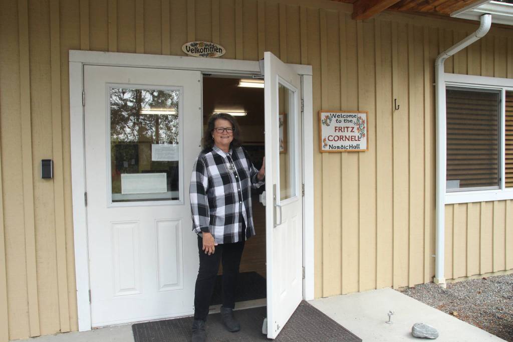 (Photo by Marina Blatt) Smith holds the Whidbey Island Nordic Lodge door open, welcoming visitors inside.
