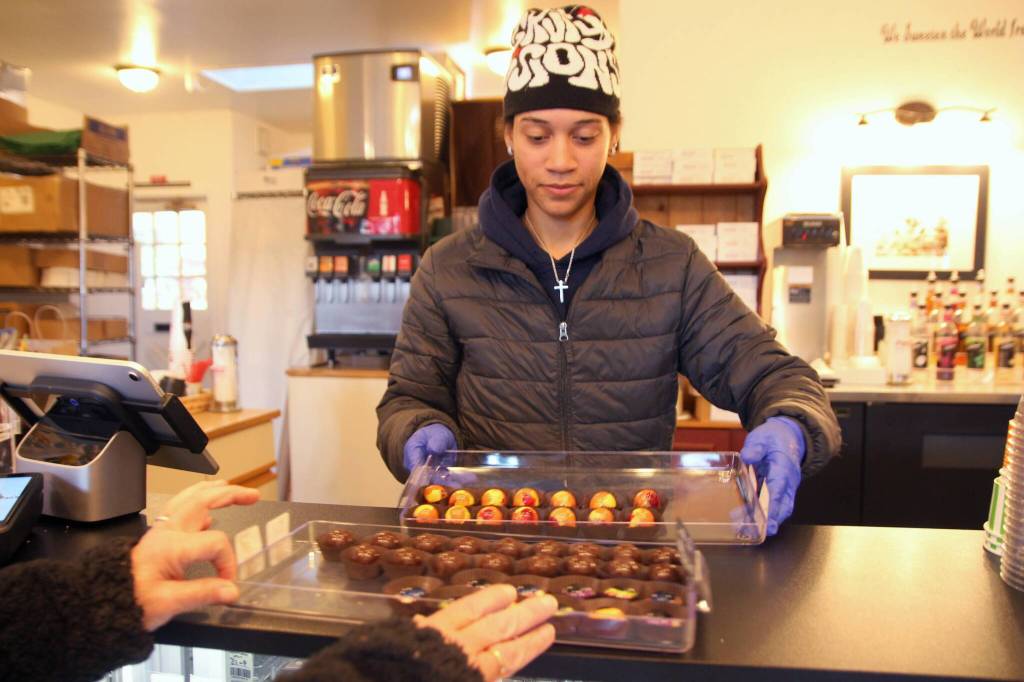 Jaden Varljen, an employee, serves up chocolates to customers.