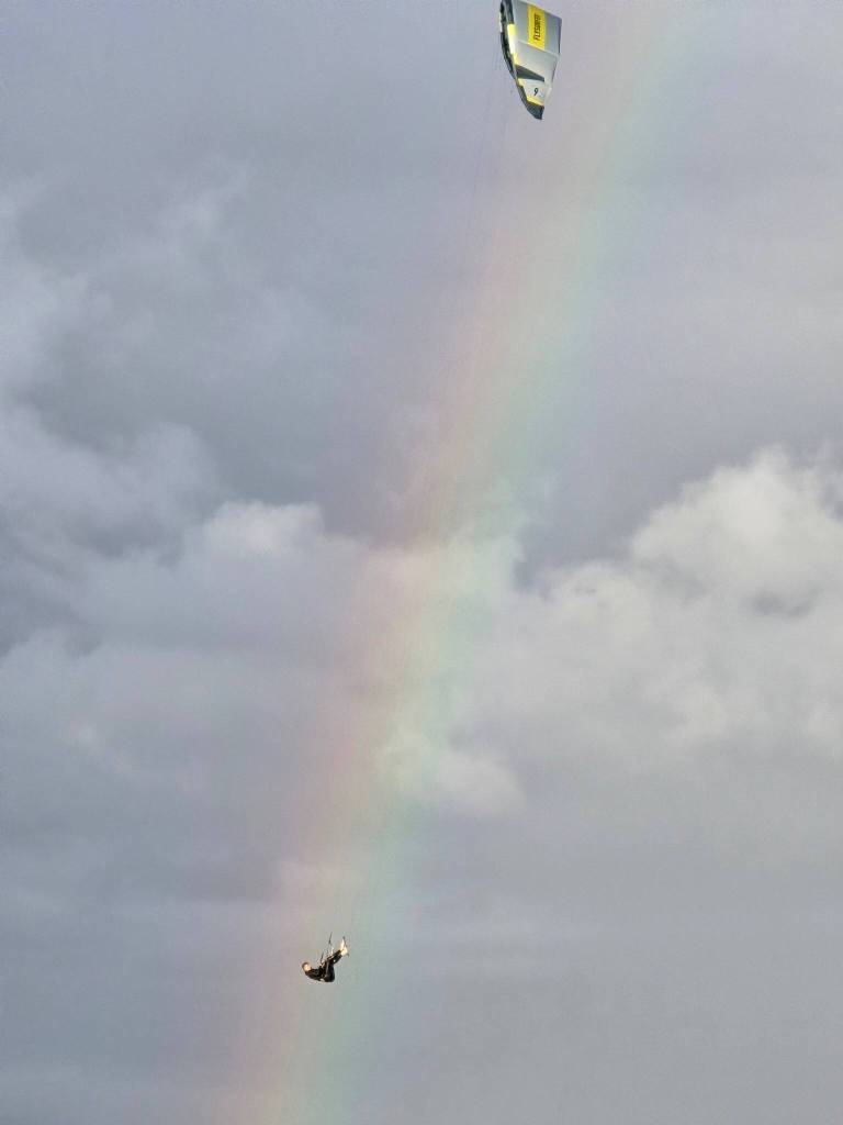(Photo by Nichol Redfearin) A kiteboarder lines up perfectly with a rainbow in the sky over Swan Lake.