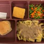 A meal tray from Island County Jail has beef gravy over noodles with mixed vegetable, corn bread and garlic roll.
