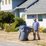 Photo provided by Island Disposal. James Andersen takes an Island Disposal recycling container out to the curb.