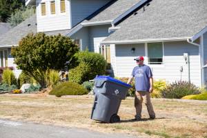 Photo provided by Island Disposal. James Andersen takes an Island Disposal recycling container out to the curb.