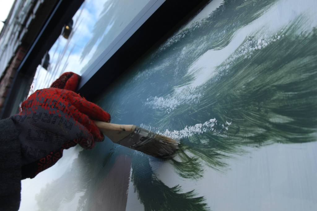 Photo by Marina Blatt. Fisher is bundled up for the cold November weather, with gloves, a thick sweatshirt and sweatpants. Her window paintings often involve spending long hours outside.