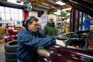 (Photo by David Welton) Senior Technician Alex Neal works on a customers car while Matt Hassrick looks on.