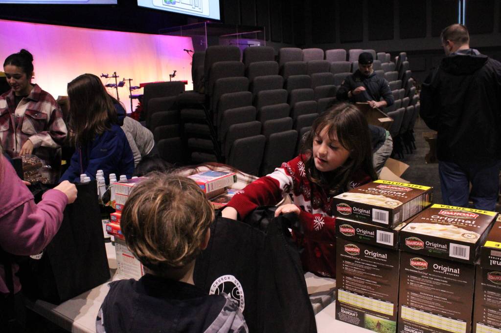 (Photo by Allyson Ballard) Volunteers put together each bag assembly line-style.