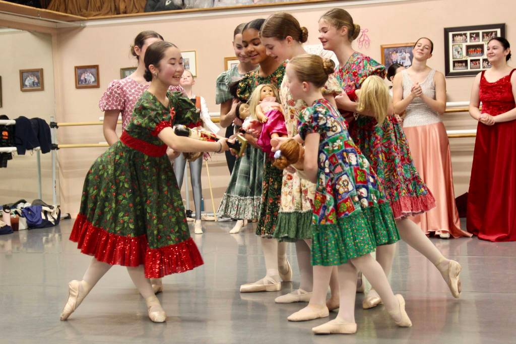 Hannah Brackeen, age 15, in the role of Clara, shows the other girls her new nutcracker toy.