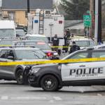 Multiple vehicles sit along Fleming Street with yellow evidence ID tents at the scene of a fatal shooting on Friday, Jan. 2, 2026 in Everett, Washington. (Olivia Vanni / The Herald)