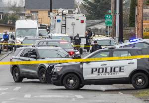Multiple vehicles sit along Fleming Street with yellow evidence ID tents at the scene of a fatal shooting on Friday, Jan. 2, 2026 in Everett, Washington. (Olivia Vanni / The Herald)
