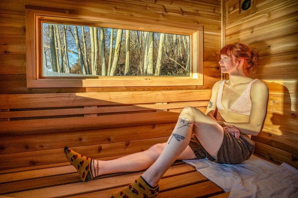 (Photo by David Welton) Maia Rezoski gazes out the window of the mobile sauna, which offers stunning views of nature wherever it is parked on Whidbey.