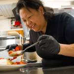Photo by David Welton. Joan Samson, owner of Merriweather Creperie, adds strawberries to a sweet crepe.