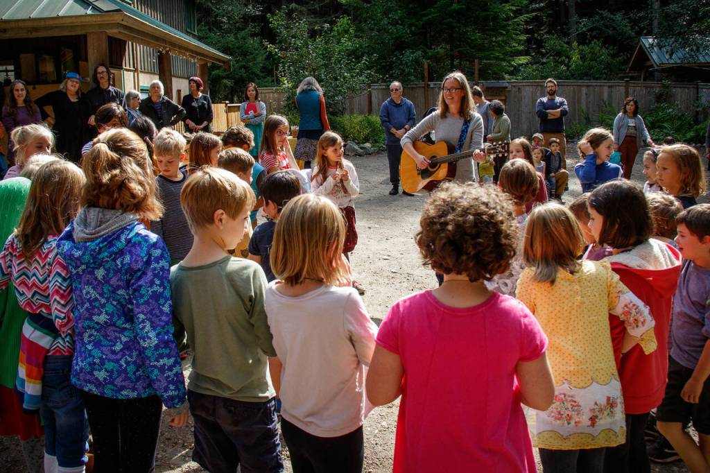 Photo by David Welton. Frances Kenney sings and plays a guitar for children at Whidbey Island Waldorf School in Clinton. The school is celebrating its 40-year anniversary.