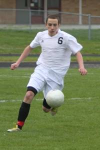 Photo by John Fisken. Tim Quinn pushes the ball up field while playing soccer for CHS in 2013.