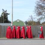 Photos by Allyson Ballard. Cloaked in red, a cluster of handmaidens moved silently through the crowd, bringing a somber energy to an otherwise energized protest.