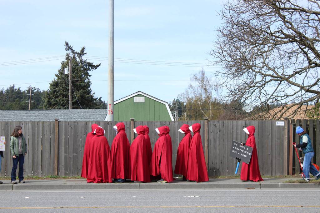 Photos by Allyson Ballard. Cloaked in red, a cluster of handmaidens moved silently through the crowd, bringing a somber energy to an otherwise energized protest.
