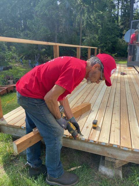 Tre Everett, president of North Whidbey Hearts and Hammers, pries boards off an old deck during a Work Day project.