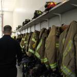 Photo by Allyson Ballard. Firefighters gear hangs openly in the apparatus bay at Station 81, whereas in Station 82, gear has its own locker.
