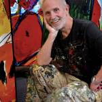 Louie Rochon paints on vast sheets of white canvas on the floor with music blasting.