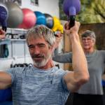 Photo by David Welton. Adam Fawcett, founder of Vibrant Fitness in Langley, lifts kettlebells with his client, Audie Black. The 62-year-old teaches functional strength training to many older clients in the community.