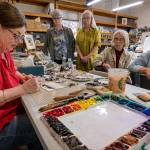 Photo by David Welton. Catherine Anderson teaches painting classes on Wednesdays. The tables are covered with hundreds of her assorted acrylic and watercolor paintings, 45 years worth. From left are Catherine Anderson, Line Goulet, Karen Shaak, Mary Erickson and Vivian Carboneau. Not pictured are Andersons two other students, Mary Clemons and Pat Matthews.