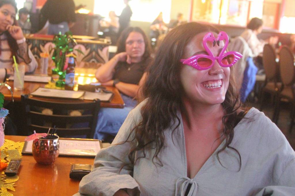 (Photo by Marina Blatt) Outside, a steady drizzle reminded a group of Love Island fans that they were, in fact, on Whidbey Island. Yet, inside, it was 82 degrees and emotionally humid. Zoey Wade watches the TV with amusement.