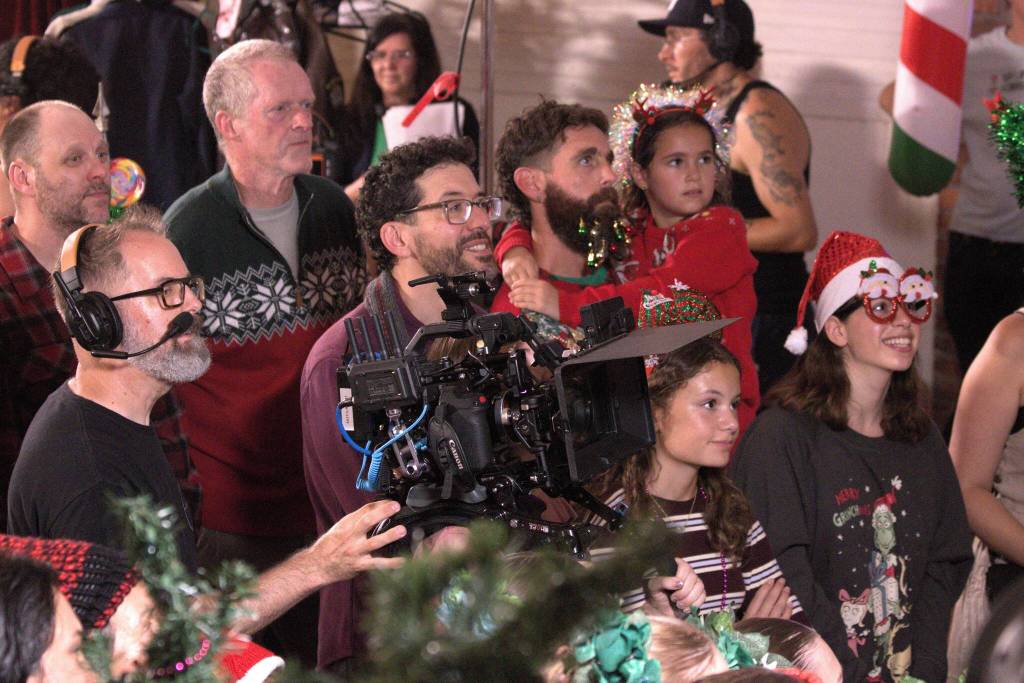 Photo by Allyson Ballard
About 65 volunteer extras  including reporter Marina Blatt, pictured to the right in Christmas glasses  gathered inside a Langley Christmas Market set, where tables overflowed with holiday décor, cookies and Christmas-themed gifts for sale, to take part in a Christmas movie.