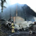 Photo by Allyson Ballard
A firefighter from South Whidbey Fire/EMS works to extinguish remaining hotspots in the aftermath of a fire Wednesday in Clinton.